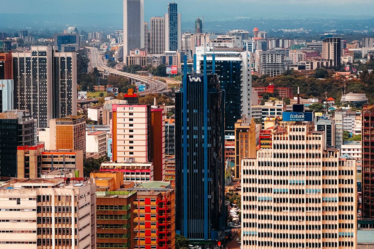 Nairobi's central business district from above, high-rise towers packed together with green suburbs and hills beyond